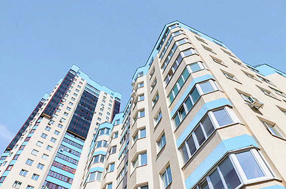 New tall modern apartment buildings against blue sky background